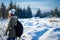 Girl backpacker walking in winter mountain forest