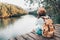 girl backpacking and sitting on the wood plank resting and looking on the river