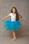 Girl ballerina in a blue tutu standing in dancing pose