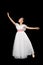 Girl ballet dancer in white long dress theatrical dancing black background. Full length, studio shot