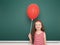 Girl with balloon near school board