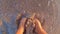 Girl bare and naked feet digging into wet sand of beach on seashore at sunset