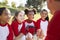 Girl baseball team in a team huddle listening to the coach