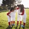 Girl baseball team in a team huddle, motivating before game