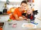 Girl in bat costume with mother creating halloween decorations