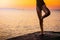 Girl on the beach at dawn doing yoga