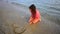 Girl on the beach drawing a heart deleted by sea