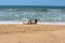 Girl on the beach laughing and waiting for refreshing wave