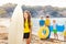 Girl on the beach standing with surf board