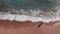 Girl on beach. Woman in red dress walking on sandy beach. Young attractive girl walking down the beach. Aerial view of sandy beach