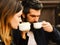 Girl and bearded guy have coffee on brown terrace background. Couple in love drinks espresso during coffee break.