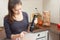 Girl beats with a mixer chicken eggs with sugar in a bowl in the kitchen