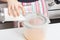 Girl beats with a mixer chicken eggs with sugar in a bowl in the kitchen