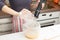 Girl beats with a mixer chicken eggs with sugar in a bowl in the kitchen