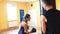 A girl beats punching bag in boxing gloves in sport gym with personal coach. Workout and Individual weight loss drills