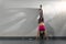 Girl with beautiful figure doing handstand. Young woman doing handstand. Slim sporty woman practicing balance pose