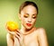 Girl with beautiful make-up holding orange fruit