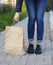 Girl in beautiful shoes leaned over a paper bag.