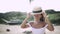 girl with a beautiful smile in a hat laughing on the beach