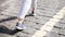 The girl is on a beautiful stone pavement. Close-up of legs.