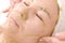 The girl in the beauty salon takes facial treatments. Close-up of a woman with a mask of green algae on her face. Beauty and