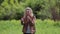 A girl beckons her boyfriend standing on a beautiful meadow.