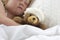 Girl in bed cuddling a teddy with bandage