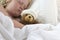 Girl in bed cuddling teddy with bandage