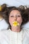 Girl in bed with daffodils in her mouth