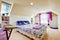 Girl bedroom with attic ceiling and beige carpet with toys.