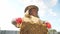 A girl beekeeper in a protective suit carries a frame with honey from a bee hive