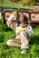 Girl beekeeper in protective white suit posing in front of wooden beehives. Young apiarist