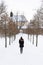 Girl from behind on the snowy winter path going to church