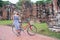 Girl with bicycle in front ancient Ayutthaya ruins , Thailand