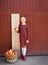 girl with big ruler standing on red wooden background. Farewell Bell. day of knowledge. beginning of the school year