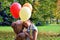 girl with big teddy bear and balloons in the park.  Problems teenagers at school