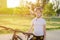 Girl with a bike in the park. An 11-year-old girl in a protective sports helmet next to a bicycle. Children`s sports