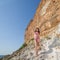 Girl in bikini among coastal rocks