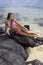 Girl in bikini on lava rocks