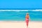 Girl in bikini and pareo walking towards ocean