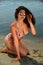 girl in bikini and sunglasses posing pretty on the beach