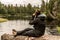 Girl with binocular sitting near Lake of two rivers in Algonquin National Park Canada Ontario natural pinetree landscape