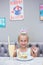 The girl at a birthday party. Joyful cheerful girl celebrates. Cocktail and cake on the table