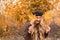 Girl in a black beret with bright red lips against the backdrop of an autumn garden