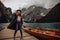 Girl in a black dress on the background of the turquoise lake in mountain. Dolomites Alps, lago di Braies