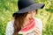 A girl in black hat is eating piece of watermelon on green background