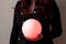 A girl in a black jacket holds a glowing orange ball