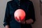 A girl in a black jacket holds a glowing orange ball