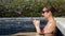 Girl in black sunglasses types on smartphone sitting in pool