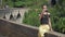 Girl in black top makes selfie sitting on bridge barrier